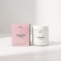 Jar of magnesium cream and pink packaging on a white background