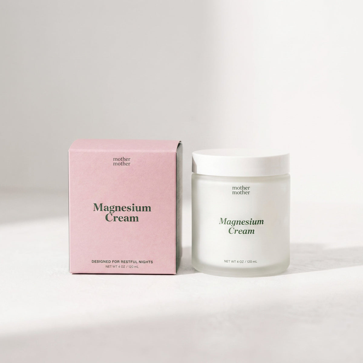 Jar of magnesium cream and pink packaging on a white background